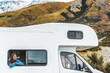 © Maridav - RV road trip tourist woman looking out the window of her motorhome on New Zealand travel. Happy young Asian girl traveling outdoors in adventure vacation driving a campervan. Home away from home.