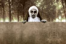 Scary Devil Nun Holding Empty Whiteboard With Haunted Forest Background
