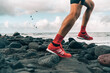 © Maridav - Running shoes of athlete man jogging on beach. Difficult terrain with wet rocks for training outdoors. Runner exercising.