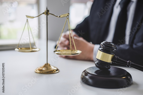Fotografía Male lawyer or judge working with contract papers, Law books and wooden gavel on