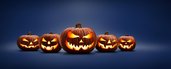 Wall Mural - five halloween, jack o lanterns, with evil spooky eyes and faces isolated against a blue lit backgro