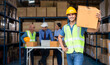 © stnazkul - Warehouse worker holding a big parcel box working with his team