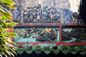 colorful decorative murals and plants in an old Chinese Buddhist Temple in Southeast Asia