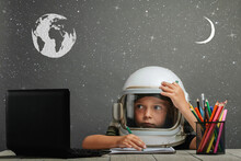 The Child Studies Remotely At School, Wearing An Astronaut's Helmet. Back To School