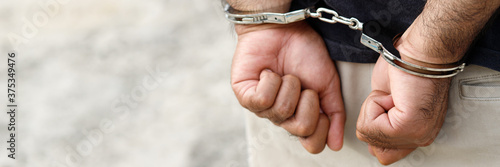 Fotografía Prisoner male criminal standing in handcuffs with hands behind back