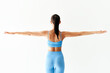 Back view of sporty woman with arms outstretched