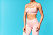 © GVS - Cropped image of fit woman torso on blue background with copy space