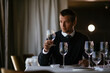 © JustLife - Handsome businessman dressed in the suit drinking wine. Businessman enjoying in the restaurant..