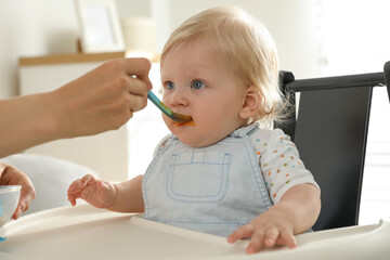 Poster - Mother feeding her cute little baby with healthy food at home