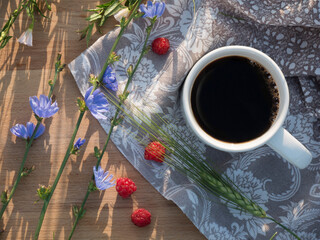 Composition of tea with raspberries in nature. Relaxation and tea drinking outside the home.