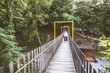 © mitarart - Woman crossing wooden suspension bridge