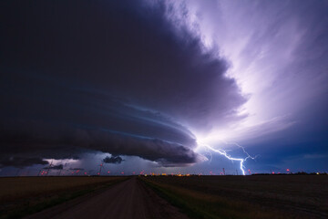 Supercell thunderstorm with lightning bolt in the night sky