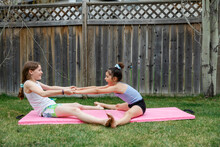 Preteen Girls Doing Gymnastics On Garden Lawn