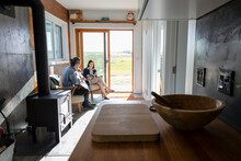 Couple Sitting By Open Door In Small Rustic Home