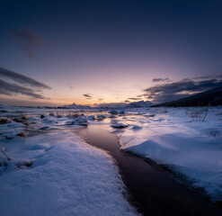 Wall Mural - lofoten islands, norway. mountains, ice with snow and clouds during sunset. evening time. winter lan