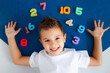 © Эллона Крицкая - the boy is lying on the blue carpet around him numbers from 1 to 10