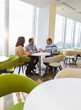 © Martin Barraud/Caia Image - Business people talking in sunny office cafeteria
