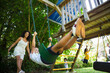 © Tom Merton/Caia Image - Happy family swinging and playing at playground set in summer yard