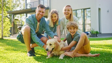 Wall Mural - Smiling Beautiful Family of Four Posing with Happy Golden Retriever Dog on the Backyard Lawn. Idyllic Family Have Fun with Loyal Pedigree Dog Outdoors in Summer House Backyard. Slow Motion Shot