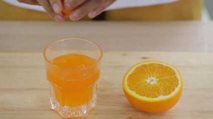 Sticker - woman is squeeze juice from an orange into glass