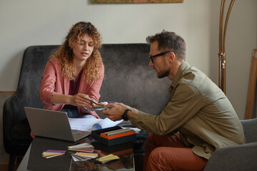 Wall Mural - two designers sitting at the table in front of laptop and examining the colored patterns at office