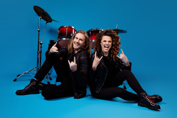 Sticker - Full length photo of two people girl man sit floor enjoy punk rock star rhythm event night club show horned symbol wear leather black jacket boots isolated bright color background