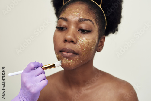 Fotomural The beautician applies a moisturizing mask to the client's face