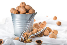 Bucket Full Of Walnuts With A Nutcracker On A White Background