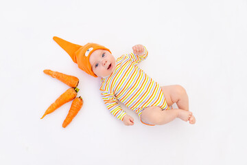 small baby girl lying on a white isolated background with a carrot, space for text, baby food concept