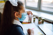 © maxbelchenko - Online remote learning. School girl  in medical mask with computer having video conference chat with teacher and class group. Homeschooling during quarantine. Covid-2019.