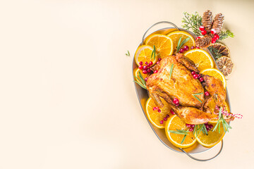 Traditional homemade Christmas chicken. Oven baked chicken with orange, cranberry rosemary and spices, over beige background copy space