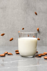 Wall Mural - Almond milk in a glass with almond ingredients on table