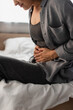 © LIGHTFIELD STUDIOS - partial view of woman suffering from stomach ache in bedroom