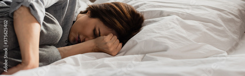 Fotografía panoramic concept of brunette woman suffering from pain and touching head while