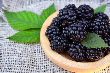 Wall Mural - Freshly picked ripe blackberries on a wooden plate on the table.Healthy eating,vegan food or diet concept.Selective focus.