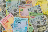Fototapeta  - Hundred US dollars banknotes and banknote with different paper bills currency Venezuelan Bolivar