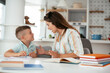 © JustLife - Mother helping her son with homework at home. Little boy learning at home..
