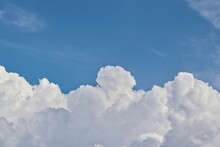 Cumulus Clouds Forming In The Sky Before The Onset Of A Thunderstorm In A Tropical Climate. Separation Between Clouds And Blue Sky Above With Copy Space.