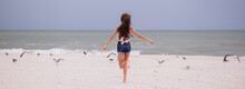 Girl Chasing Birds On The Beach 