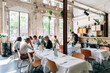 © VISUALSPECTRUM/Stocksy - Many Young People Chatting in Bright Modern Restaurant