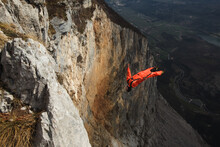 Basejumper exiting from a cliff performing a backflip