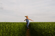 © Helen Rushbrook/Stocksy - A little girl dancing in a field. Copy space.