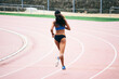 © BONNINSTUDIO/Stocksy - Back view of an african american female sprinter running on an athletics track.