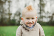 © Rob and Julia Campbell/Stocksy - Portrait of a cute young toddler smiling in a field