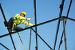 © visoot - Construction workers wearing safety harness belt working at high place at building site.