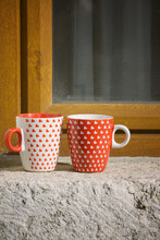 Two Coffee/ Tea Cups On A Window