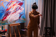 © DC Studio - Painter wearing virtual reality headset in art studio. Modern artwork paint on canvas, creative, contemporary and successful fine art artist drawing masterpiece