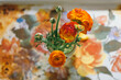 © Kelli Seeger Kim/Stocksy - Orange ranunculus flowers on vintage tray