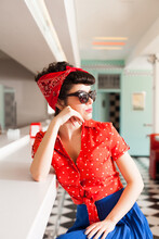 Side Portrait Of Stylish Pin Up Woman With Sunglasses At Vintage Cafe.