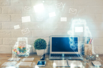 Desktop computer background in office and flying envelops hologram drawing. Double exposure. Electronic mail concept.